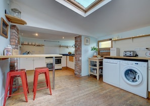 The well equipped large kitchen with low ceiling in parts, original wooden floors, breakfast bar and large range cooker