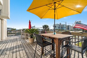 Your private outdoor oasis awaits! This front balcony provides ample seating under the shade of an umbrella, ideal for al fresco meals and soaking in the atmosphere.