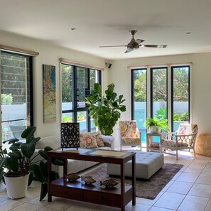 Comfortable light filled living area with view to pool 