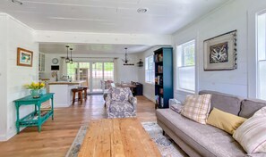 Another view through the living room, showing a little more of the kitchen and out onto the spacious porch. Note the pine shiplap painted white. The whole house is like this.