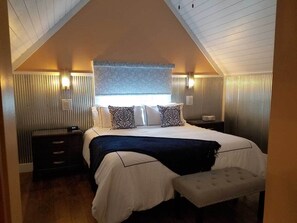 Master bedroom with king bed, bench and closet. 