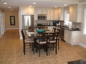 Kitchen has seating for eight, stainless steel appliances, and an outside view