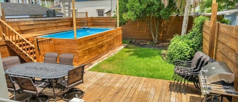 Lush outdoor area with pool and grill!