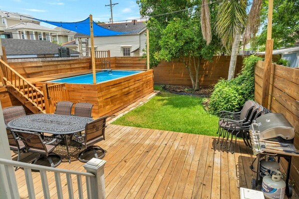 Lush outdoor area with pool and grill!