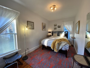 Bedroom 2 is spacious and private, with a queen sized bed and yard view.