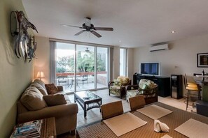 The living room has a sliding door that leads to a large balcony.