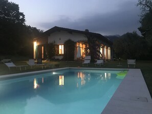 the house in the evening and light in the swimming pool