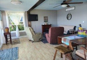 Cozy living and dining area has great lake views, roku tv, fan and fireplace.