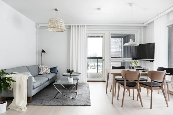 Open plan living room and dining area, with an access to the balcony.