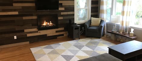 Living room with gas fireplace and flat screen smart TV.   