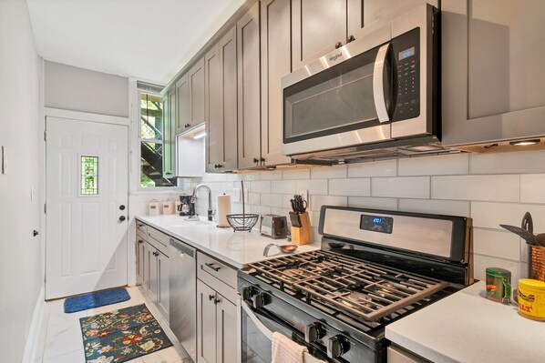 Beautiful kitchen with new stainless steel appliances and quartz countertop.