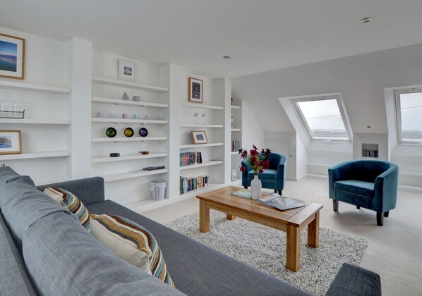 The more formal sitting area with sofa and two upholstered tub chairs, LED lighting, shelving, CD/cassette player, radio, books and a choice of board games