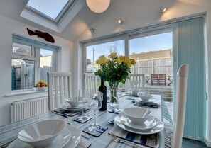 Two large velux windows, a side window and patio doors make this an airy and pleasant social space