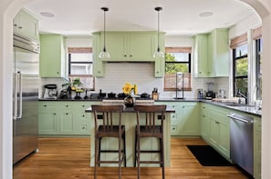 Chefs kitchen: 6 burner and griddle gas stove, 48" Thermador fridge, and island.