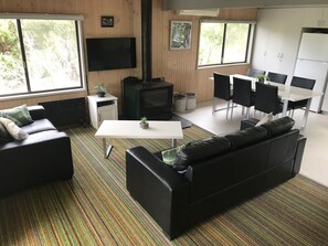 Lounge and dining area with wood heater and split system heating and cooling