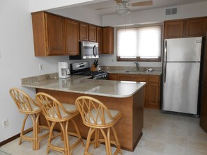 Kitchen with stainless steel appliances and seating for three