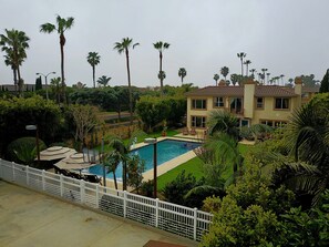 Backyard with sport court, lawn and pool area