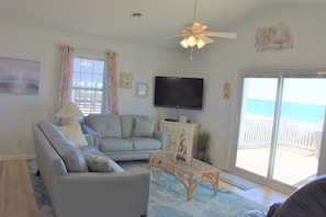 Living room that opens onto deck overlooking ocean