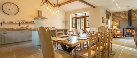 Red Stag Lodge: Kitchen/ dining/ sitting area with hand-made dining table, antler chandelier, large leather sofas and wood burning stove