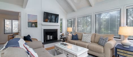 Vaulted ceilings make the living area spacious. A wall of windows lets in plenty of light