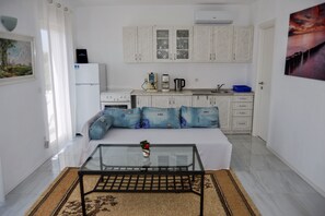 Living room with sofa bed, kitchen and dining area.