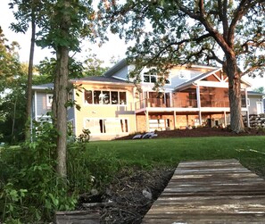 Back of house on a late summer afternoon. Wood path leads to the fire pit.