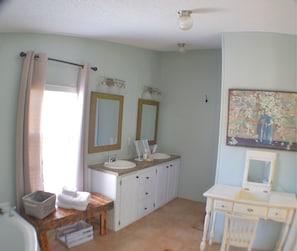 Master bathroom with lit vanity mirror and separate soaking tub and shower