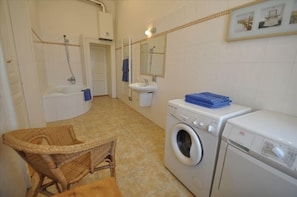 Bathroom with bath tub, sink, washer and dryer