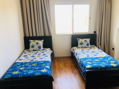 Une chambre avec deux lits simple et placard encastré .