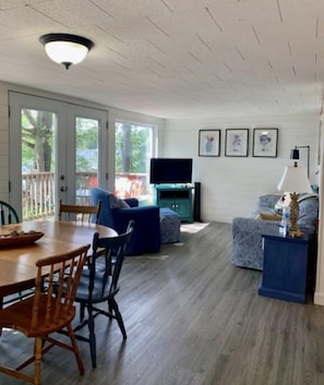 Living room and dining area overlook the deck and lake