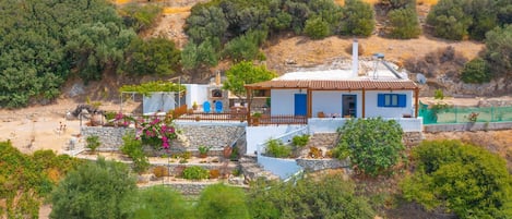 The house is perched on a hillside amidst olive trees