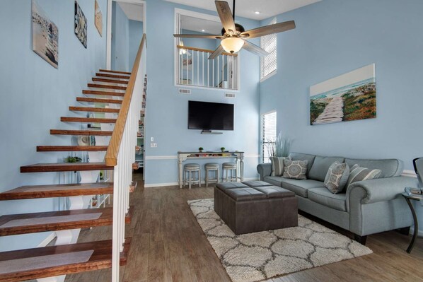 This stylish and contemporary living space features a floating staircase leading up to the master bedroom.