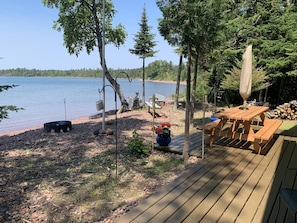 Lakeside deck includes picnic table, fire ring and gas grill.