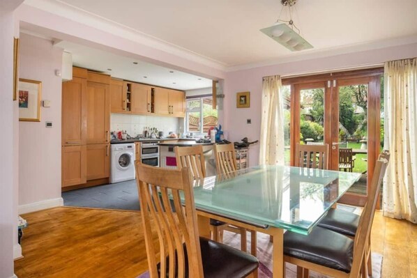 Large dining table by the kitchen and next to the patio doors