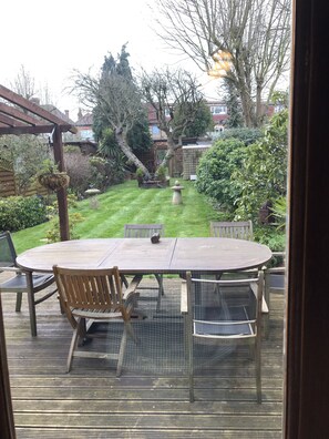 Patio with outdoor dining table and lovely garden.