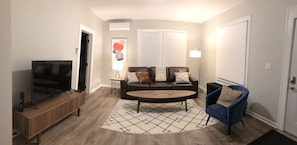 Panoramic view of living room, which is open to the dining room.