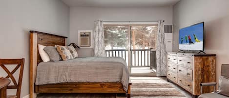 Serene queen bed next to charming outdoor patio, perfect for relaxation.