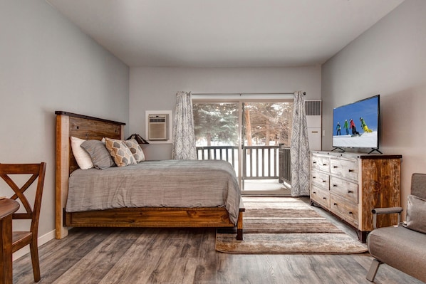 Serene queen bed next to charming outdoor patio, perfect for relaxation.