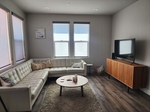 Comfy faul leather couch with a Large screen smart TV
