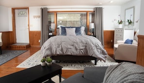 Bedroom area includes queen bed, dresser, & recliner