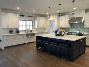 Kitchen opens out onto 600+ sq ft mahogany back porch overlooking pool 