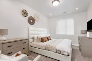 Master suite featuring a king and a large flat screen tv