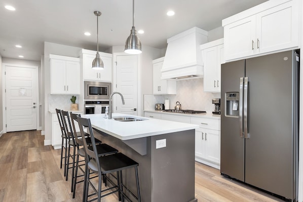 fully stocked gourmet kitchen featuring extra seating at the bar