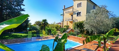 La casa familiare con splendida piscina esterna e sedie a sdraio a disposizione