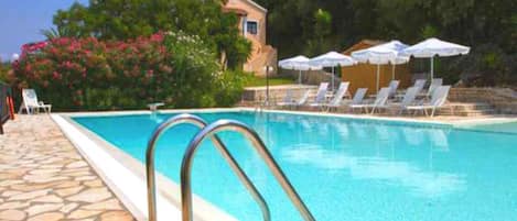 Relax around the pool overlooking the Ionian Sea