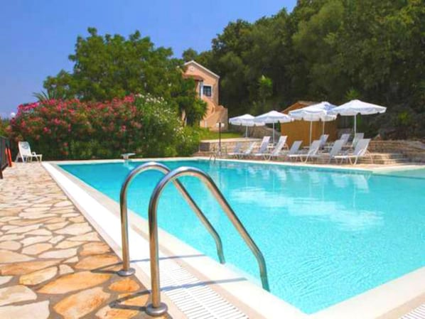 Relax around the pool overlooking the Ionian Sea