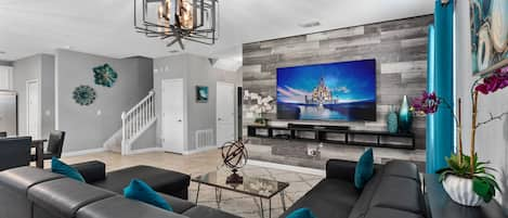 Living room with large 85" 4K smart TV and a beautiful wrap around sectional