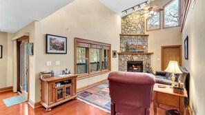 Living room area with wood burning fireplace, tv, recliner and couch to relax.