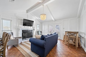 The living room is bright and spacious— with doors leading out to the sunny deck