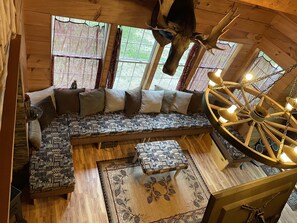 Looking down from open loft to livingroom large couch seats many.